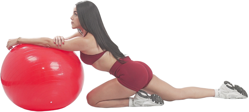 Entrenadora estirando apoyada en una pelota de pilates